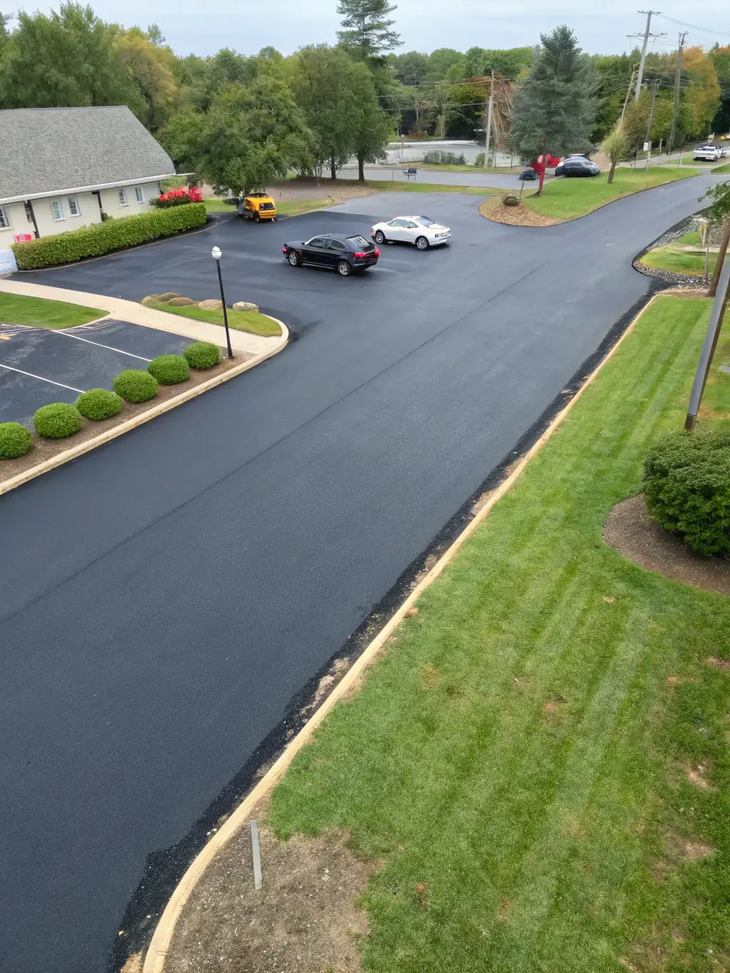 An image of freshly sealed asphalt, showcasing a smooth, black surface with a clear, even finish. The photo should emphasize the protective and aesthetic benefits of sealing.